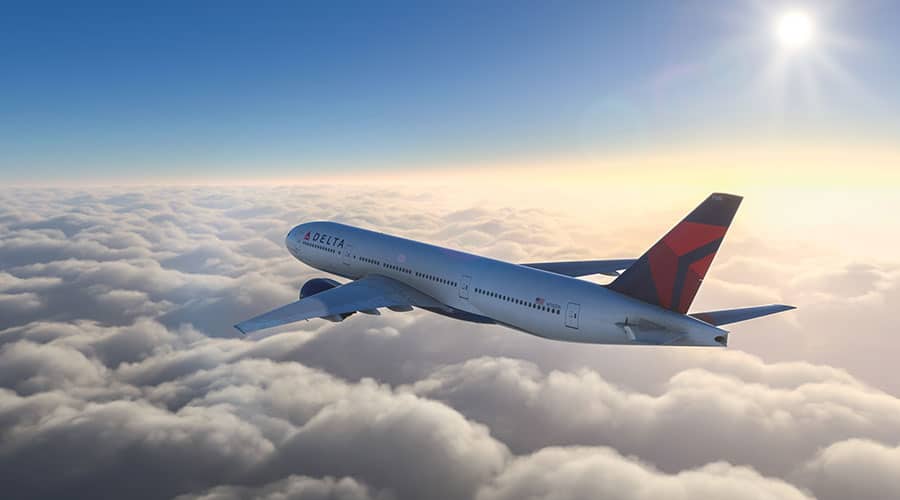 commercial aircraft flying above clouds